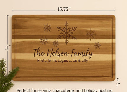 Size and dimensions graphic showing a personalized acacia cutting board with snowflake engraving and “The Nelson Family,” measuring 15.75 inches by 11 inches and 1 inch thick, with a note that it is ideal for serving and charcuterie and that each board’s woodgrain is unique.