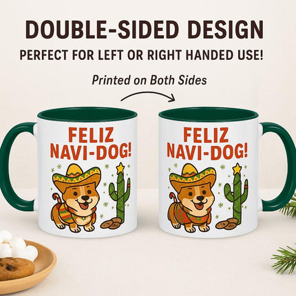 "Two identical Christmas mugs with green handles and interiors, each featuring a cute cartoon corgi in a sombrero next to a cactus and the text 'Feliz Navi-Dog!' The mugs are positioned side by side to show that the design is printed on both sides. Text above reads 'Double-Sided Design – Perfect for Left or Right Handed Use! Printed on Both Sides.' A plate with cookies and marshmallows sits nearby on a light surface with holiday greenery accents."