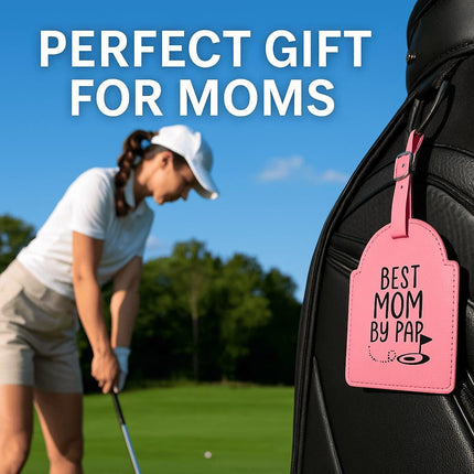 "Pink leather golf bag tag engraved with 'Best Mom by Par' attached to a black golf bag. In the background, a woman wearing a white cap, white polo, and khaki shorts is preparing to swing her golf club on a sunny green course. Text at the top reads 'Perfect Gift for Moms.'"