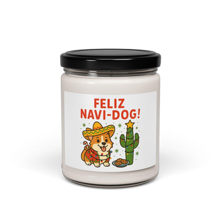 "White candle in a glass jar with a black lid featuring the design 'Feliz Navi-Dog!' and an illustration of a cheerful Corgi wearing a sombrero and holiday scarf beside a decorated cactus topped with a star. The candle is set against a clean white background."