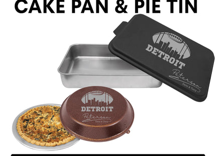&quot;Personalized football-themed bakeware set featuring a black aluminum cake pan and a brown pie tin, both engraved with the Detroit skyline inside a football outline. The cake pan reads &#39;Detroit Peterson Darrin & Terry,&#39; and the pie tin is shown with a baked quiche inside. Text above says &#39;Personalized Cake Pan & Pie Tin,&#39; and below reads &#39;Laser Engraved Gift.&#39;&quot;