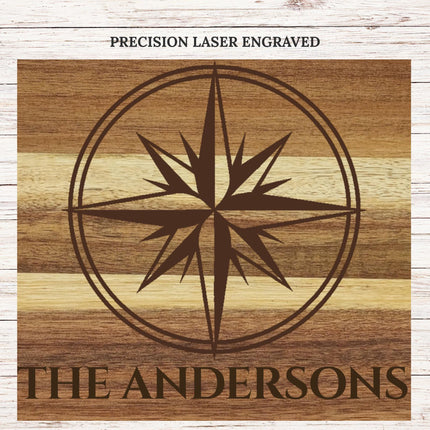 Close up of deep laser engraved compass design on acacia wood cutting board showing detailed craftsmanship and wood grain