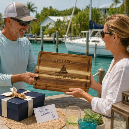 Key Largo Florida Keys personalized cutting board being given as a gift on a tropical dock with boats water and coastal background