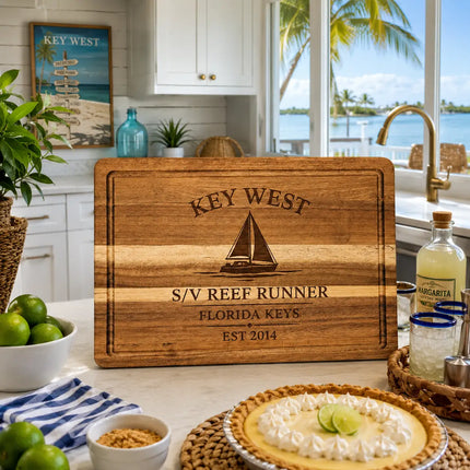 Personalized Harbor Collection cutting board displayed in a bright Key West inspired coastal kitchen featuring tropical decor, waterfront style design, premium acacia wood, and custom harbor engraving.