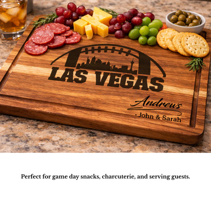 Personalized Las Vegas football cutting board used as a charcuterie serving board with meats cheese grapes and crackers on a kitchen countertop