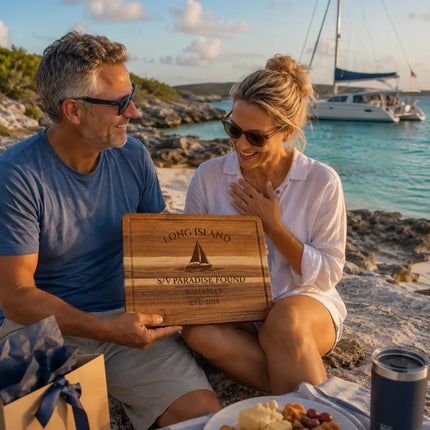 Long Island Bahamas personalized cutting board being shared between cruisers at a remote tropical anchorage with rugged coastline and turquoise water