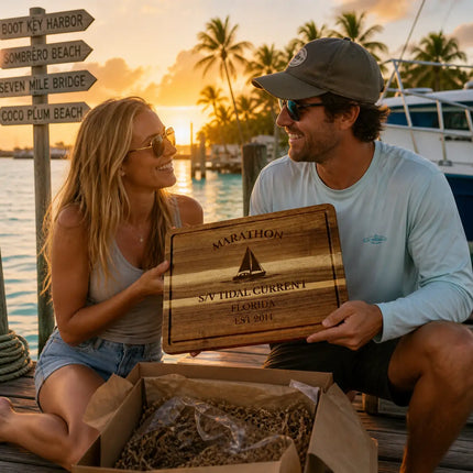 Marathon Florida personalized cutting board being given as a gift on a dock at sunset with palm trees boats and Florida Keys marina background