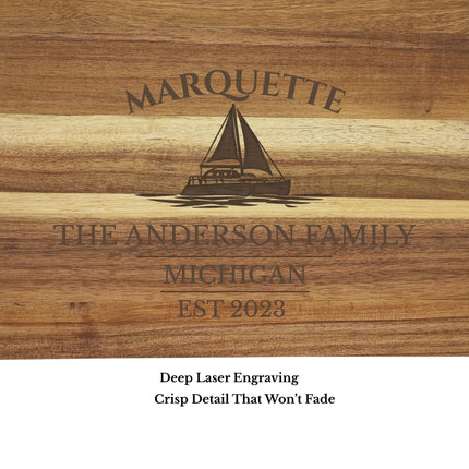 Close up of engraved sailboat and personalized text on Marquette Michigan acacia wood cutting board