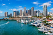 Sailboats and downtown skyline at Miami Harbor during golden hour along Biscayne Bay