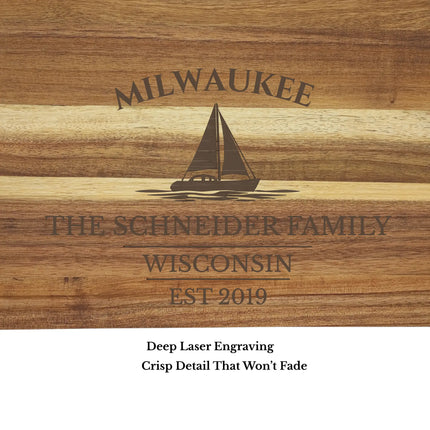 Close up of engraved sailboat design and personalized text on Milwaukee Wisconsin nautical cutting board showing detailed wood grain