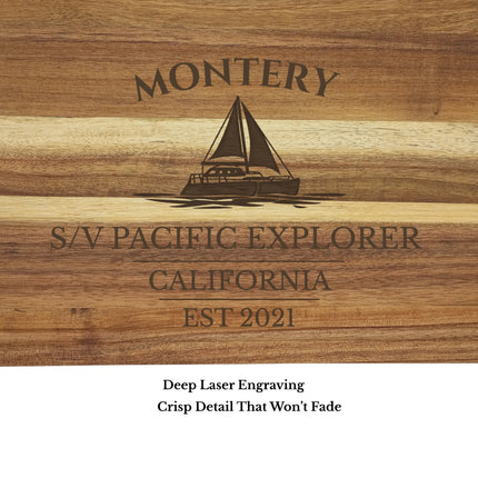 Close up of Monterey California sailboat cutting board engraving showing detailed laser etched sailboat design and acacia wood grain