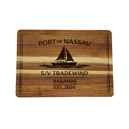 Wooden cutting board with engraved text and sailboat illustration on a white background