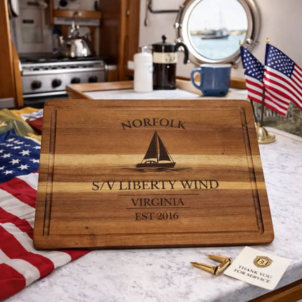 Norfolk Virginia personalized sailboat cutting board displayed in a boat galley with American flags and nautical setting