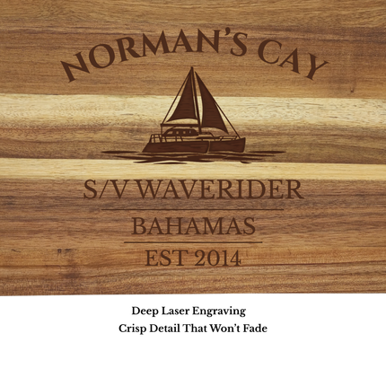 Close up of Norman’s Cay Bahamas sailboat cutting board engraving showing detailed sailboat design and acacia wood grain