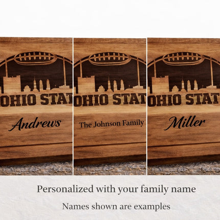 Ohio State football cutting board showing personalization examples with different family names laser engraved in dark brown on acacia wood
