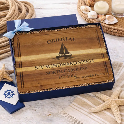 Oriental sailboat cutting board presented in nautical themed gift box with rope starfish shells and coastal decor