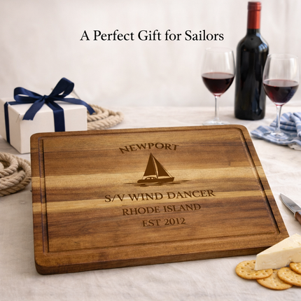 Personalized sailboat cutting board displayed as a nautical gift with wine cheese and coastal table setting