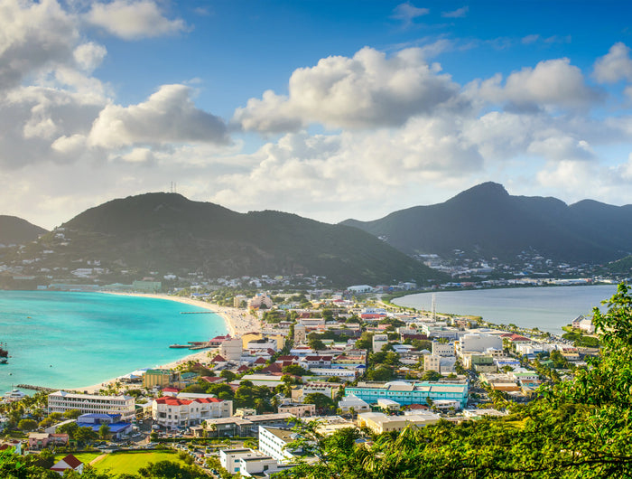 Aerial view of Philipsburg Harbor and Great Bay in Sint Maarten featuring turquoise Caribbean waters, waterfront development, beaches, and surrounding hills