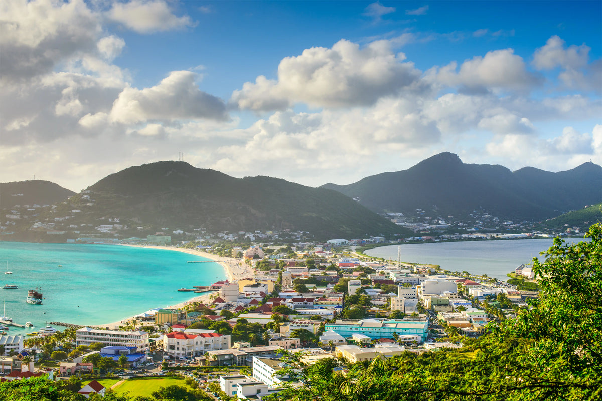 Aerial view of Philipsburg Harbor and Great Bay in Sint Maarten featuring turquoise Caribbean waters, waterfront development, beaches, and surrounding hills
