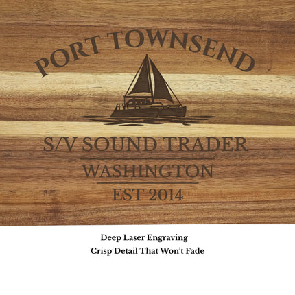 Close up of Port Townsend Washington sailboat cutting board engraving showing detailed sailboat design and acacia wood grain