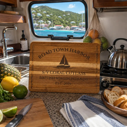 Wooden cutting board with 'Road Town Harbor' branding in a kitchen with a view of the ocean.