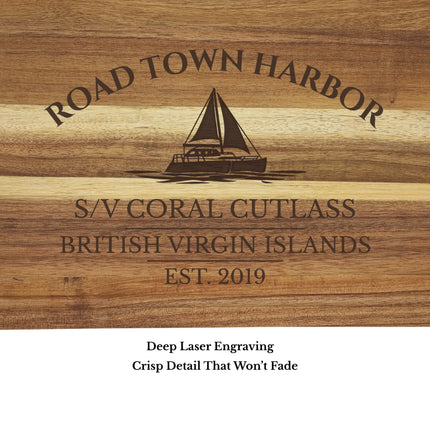Close up of Road Town Harbor British Virgin Islands sailboat cutting board engraving showing detailed sailboat design and acacia wood grain