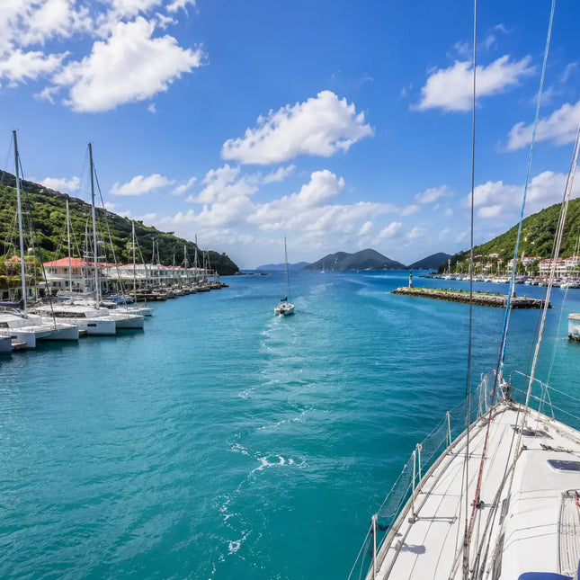 Sailboat departing Road Harbour toward Sir Francis Drake Channel, showcasing the crystal-clear waters and island scenery that make the British Virgin Islands a world-class cruising destination.
