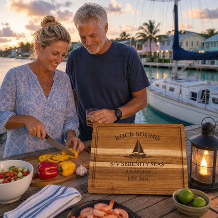 Rock Sound Bahamas personalized cutting board being used during a relaxed outdoor harbor meal beside sailboats and calm turquoise water in Eleuthera