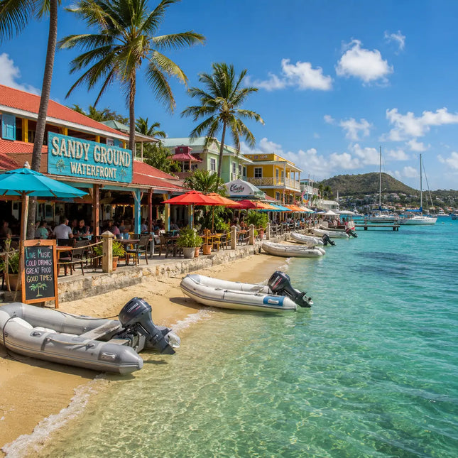Waterfront restaurants, dinghies, anchored sailboats, and turquoise waters along Sandy Ground in Road Bay Harbor, Anguilla.