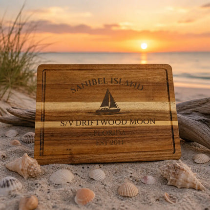 Sanibel Island Florida sailboat cutting board on sandy beach with seashells driftwood and soft Gulf Coast sunset background