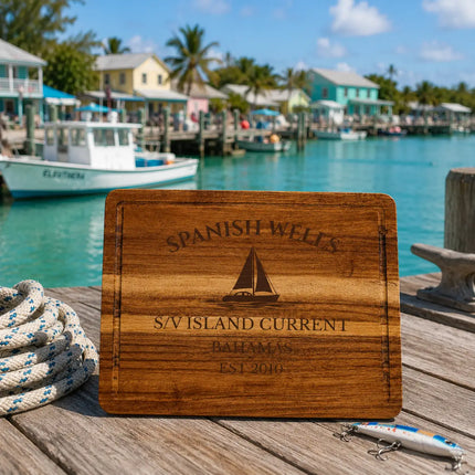 Spanish Wells Bahamas sailboat cutting board overlooking calm turquoise harbor water with small fishing boats and colorful waterfront homes