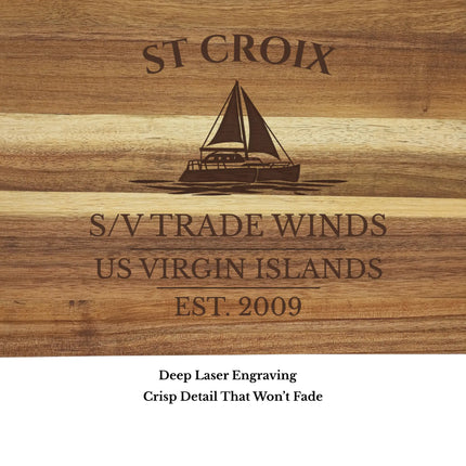Close up of St Croix US Virgin Islands sailboat cutting board engraving showing detailed sailboat design and acacia wood grain