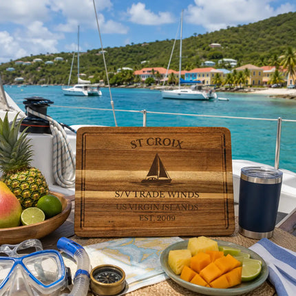 St Croix US Virgin Islands sailboat cutting board displayed beside tropical Caribbean coastline with turquoise water sailboats palm trees and island scenery