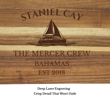 Close up of Staniel Cay Bahamas sailboat cutting board engraving showing detailed sailboat design and acacia wood grain