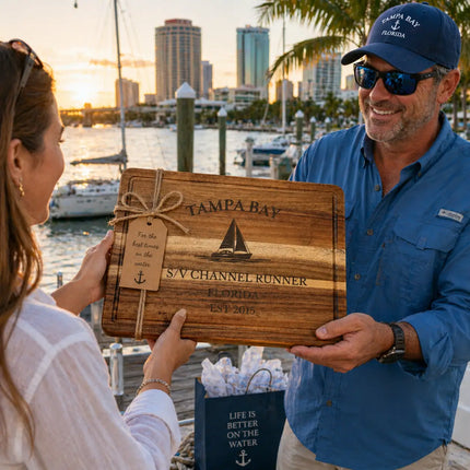 Tampa Bay Florida personalized cutting board being given as a gift on a marina dock with boats water and city skyline in background