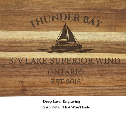 Close up of custom engraved Thunder Bay Ontario sailboat cutting board showing sailboat design personalized boat name and established date