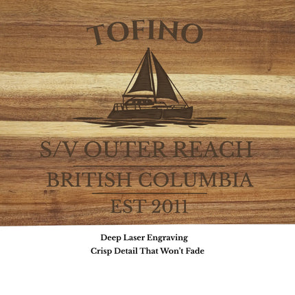 Close up of Tofino British Columbia sailboat cutting board engraving showing detailed sailboat design and natural acacia wood grain