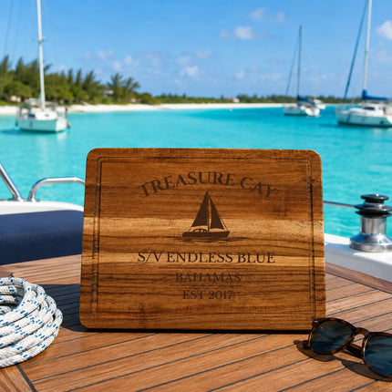 Treasure Cay Bahamas sailboat cutting board overlooking crystal-clear turquoise water with white sand beach and anchored sailboats in the Abacos